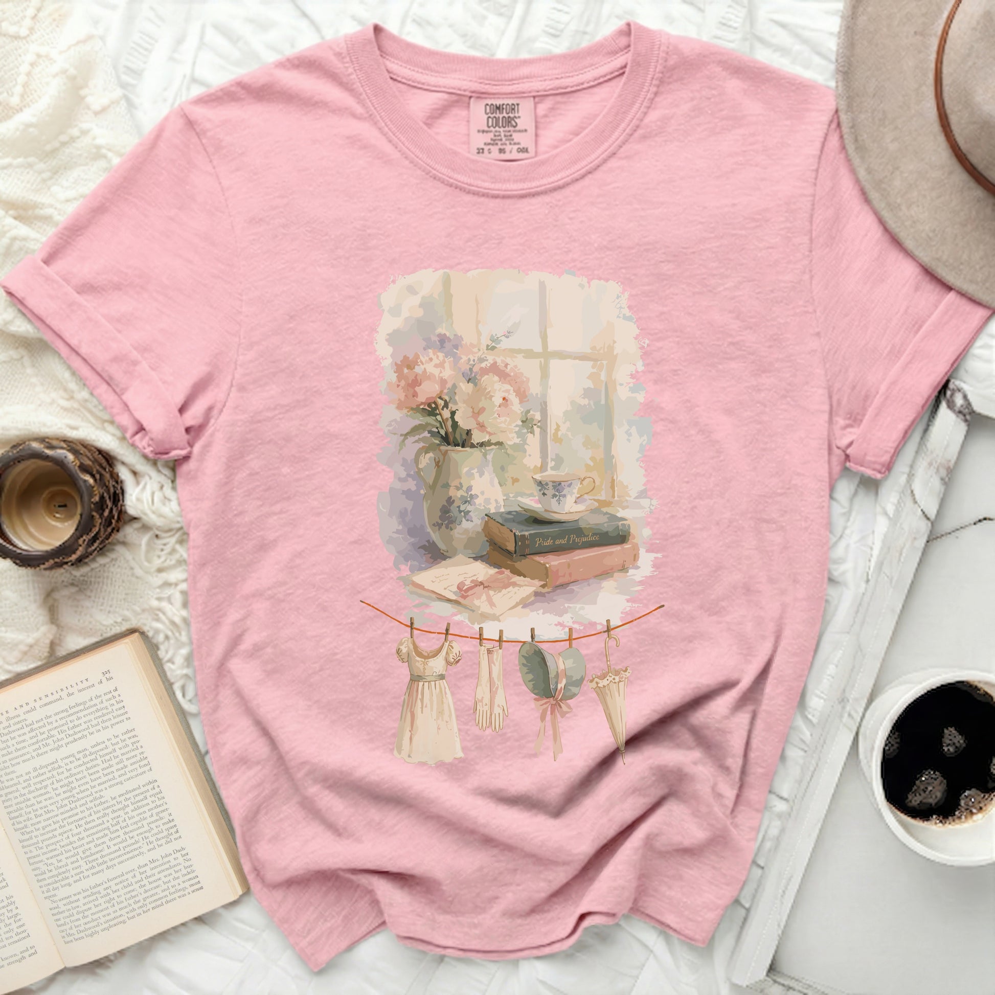 Pink t-shirt with a watercolor print of a window scene and clothesline.