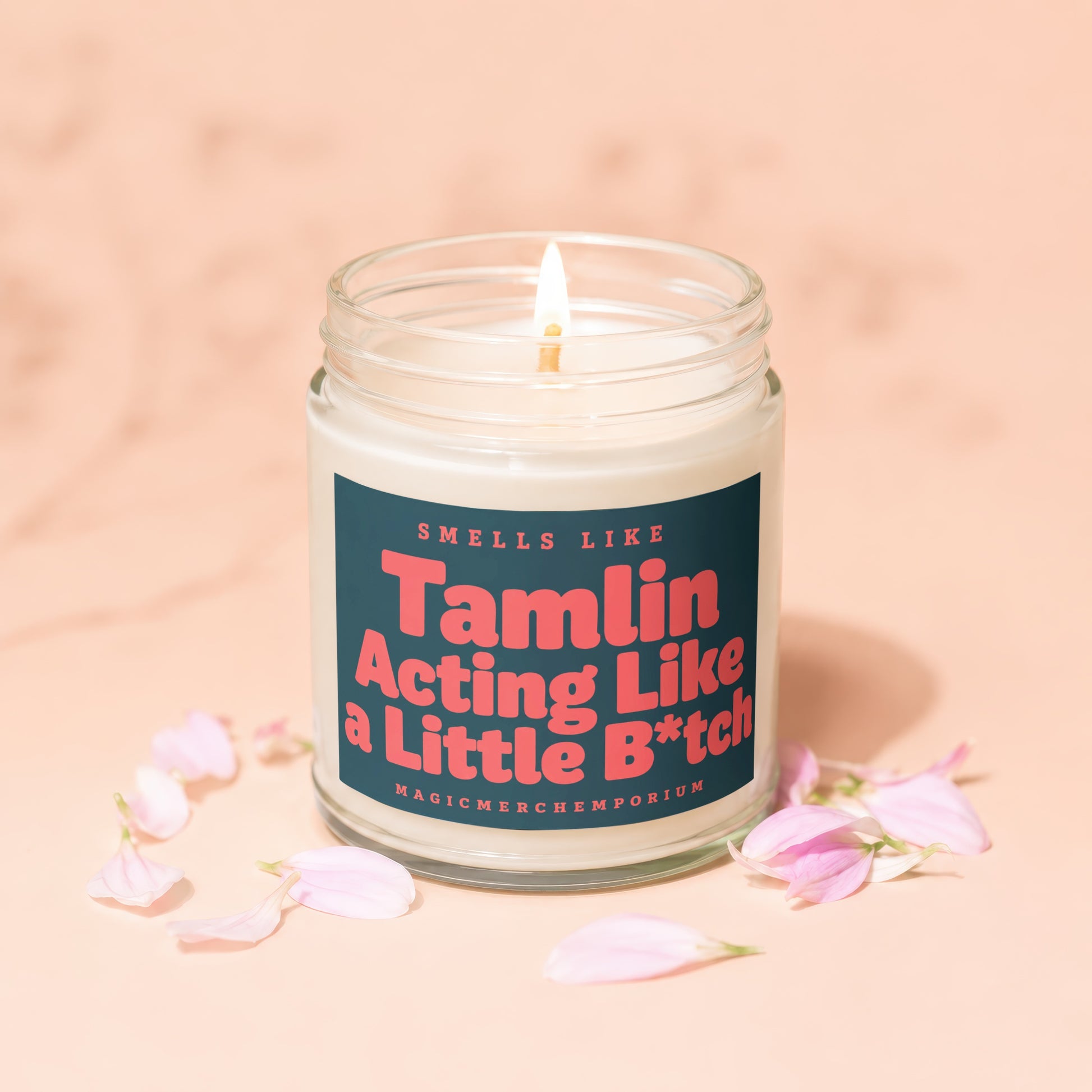 Glass jar candle with lit wick, reads "Smells Like Tamlin Acting Like a Little B*tch"