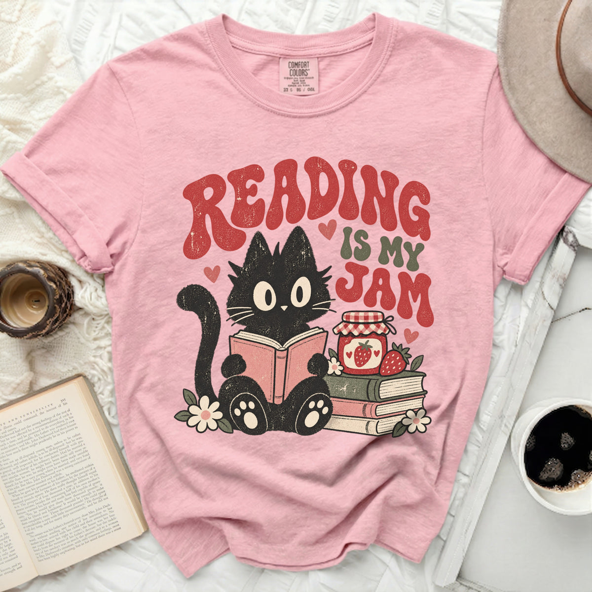 Pink t-shirt with graphic of black cat reading, "Reading is My Jam" text, and jam jar.