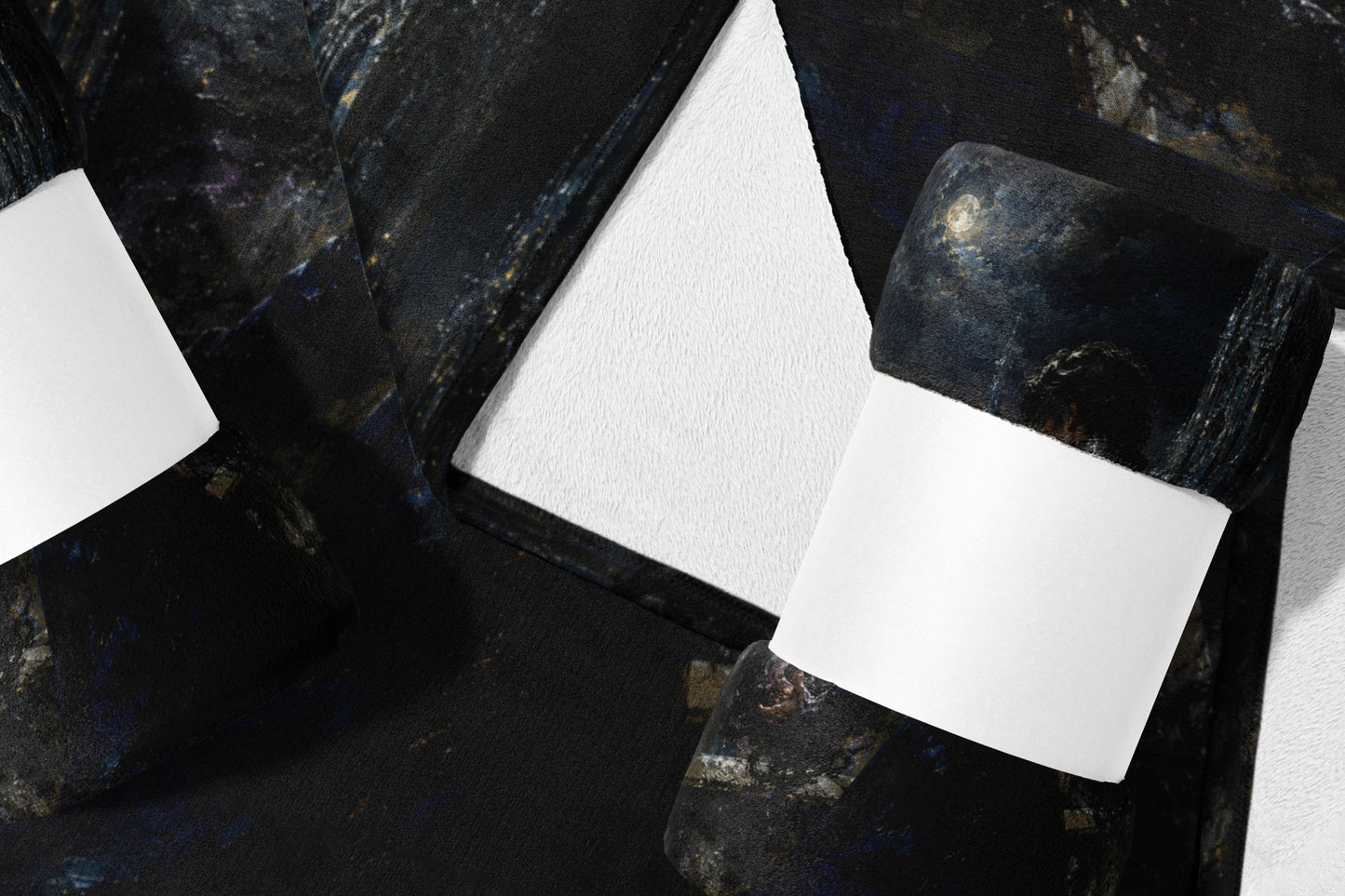 Dark textured blanket with celestial print and white bands on a white background.