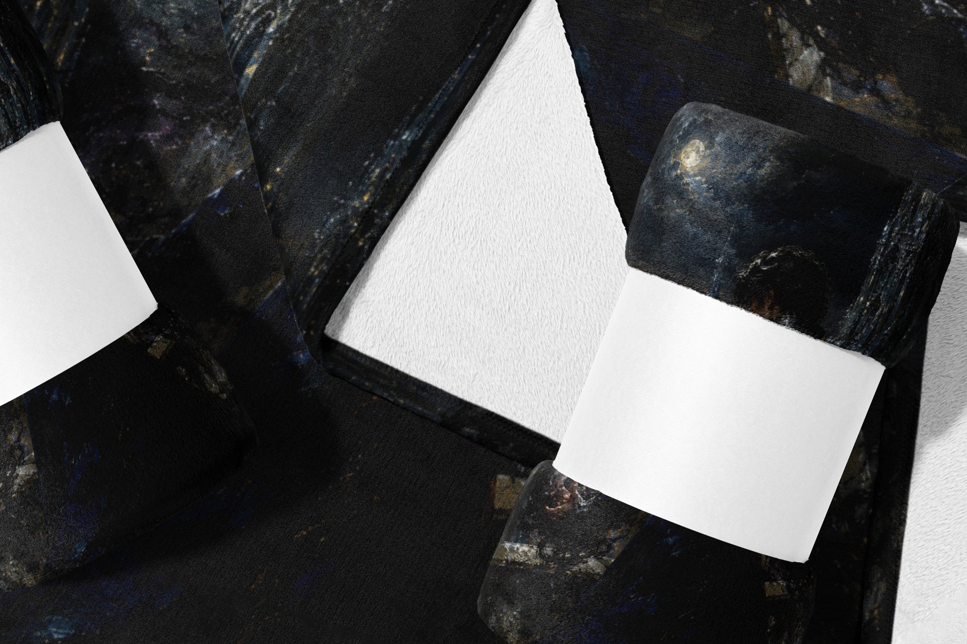 Dark textured blanket with celestial print and white bands on a white background.