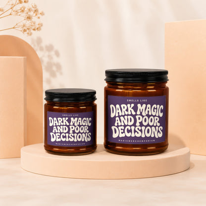 Two amber glass candles with purple labels reading "Dark Magic and Poor Decisions."
