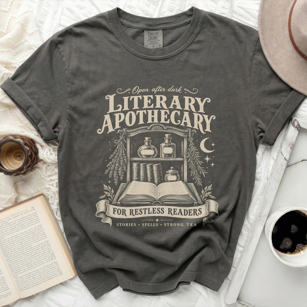 "Literary Apothecary For Restless Readers" graphic on a charcoal grey t-shirt.