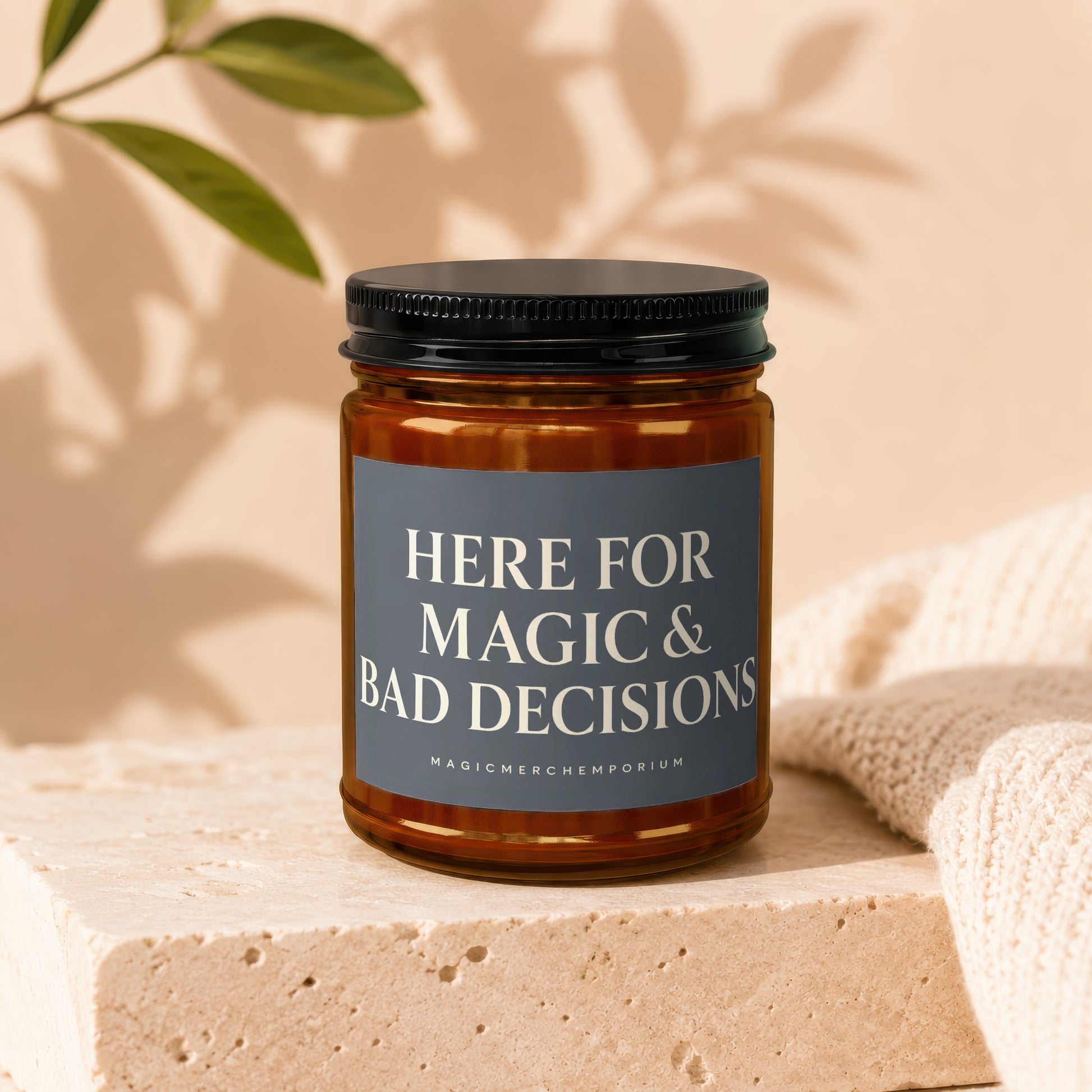Amber candle with black lid and label reading "HERE FOR MAGIC & BAD DECISIONS".