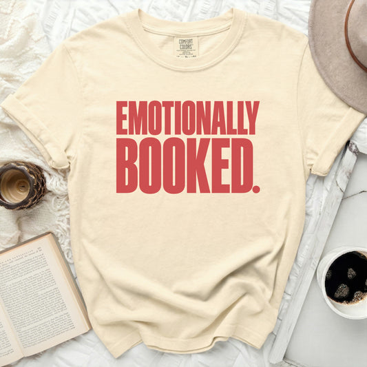 Cream t-shirt with red text that reads "EMOTIONALLY BOOKED."