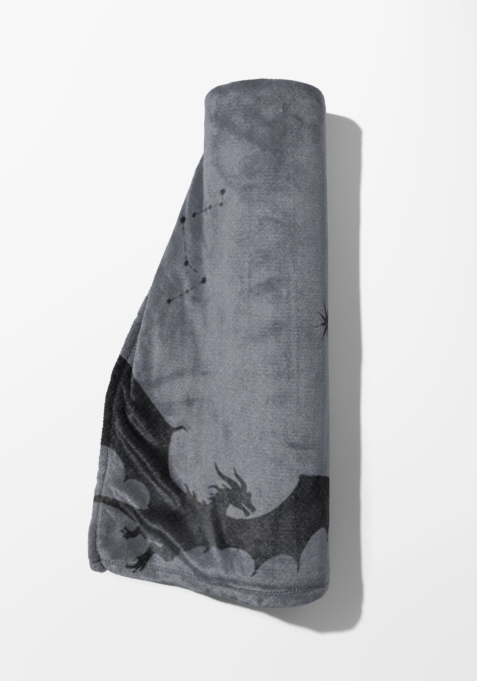 Rolled gray blanket with a black dragon and constellation pattern.