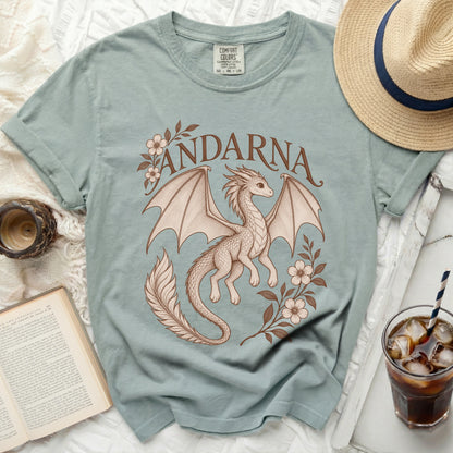 Sage green t-shirt featuring a brown illustration of a dragon, floral branches, and the text Andarna.