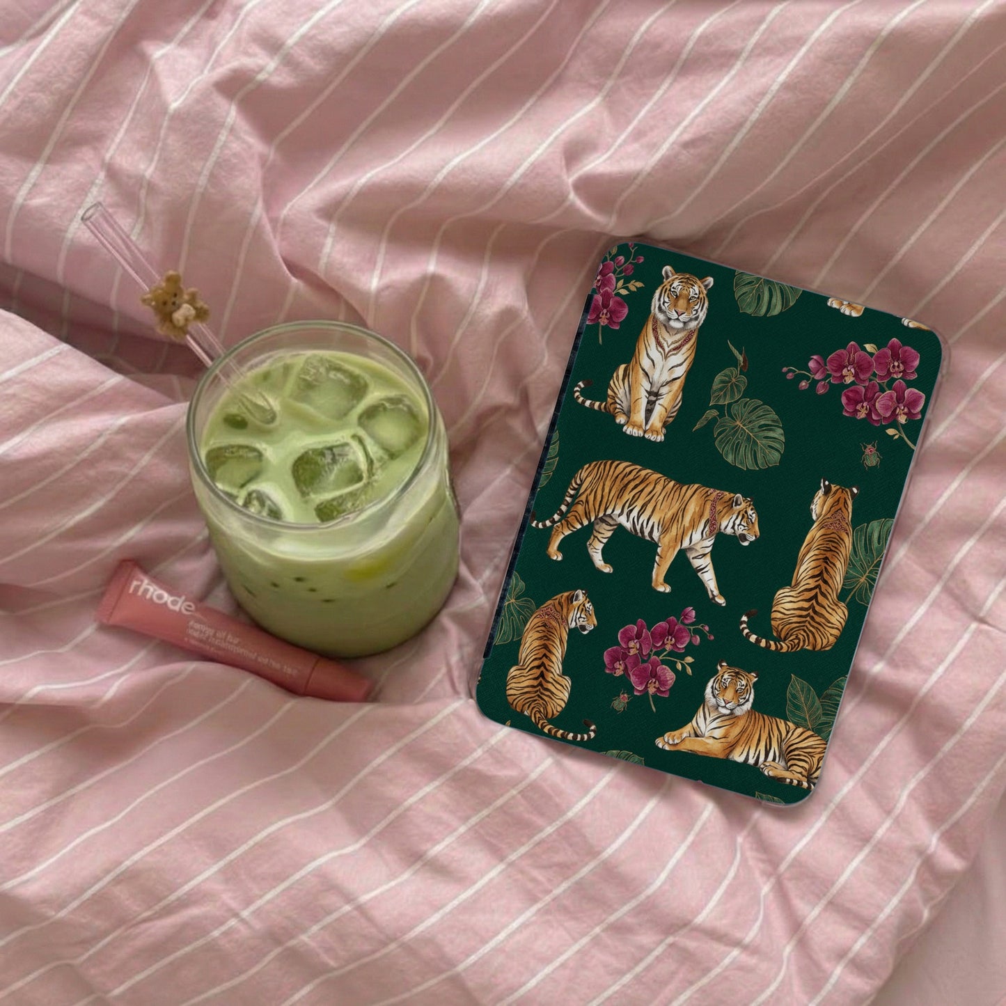 Ipad case with multiple tigers and floral pattern on green background.