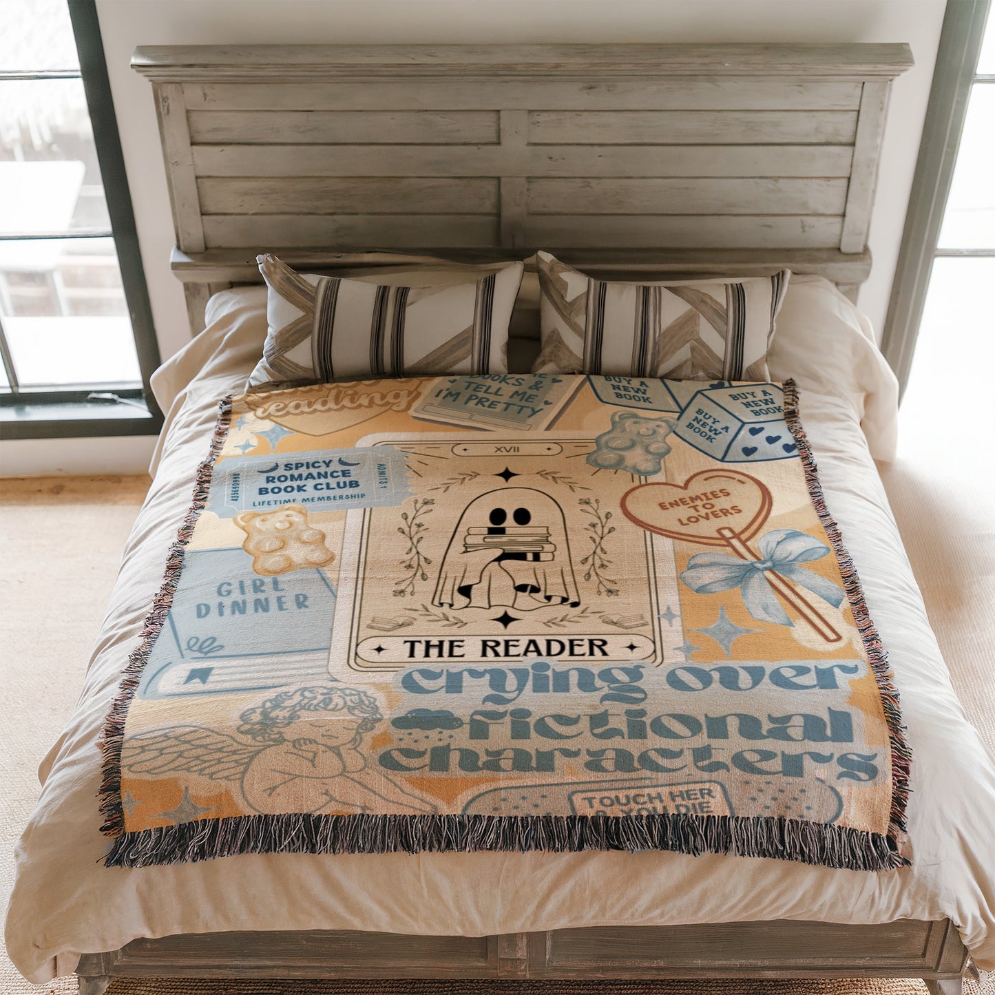a bed with a blanket that has various text and illustrations on it, including a ghost, a book, and other decorative elements.
