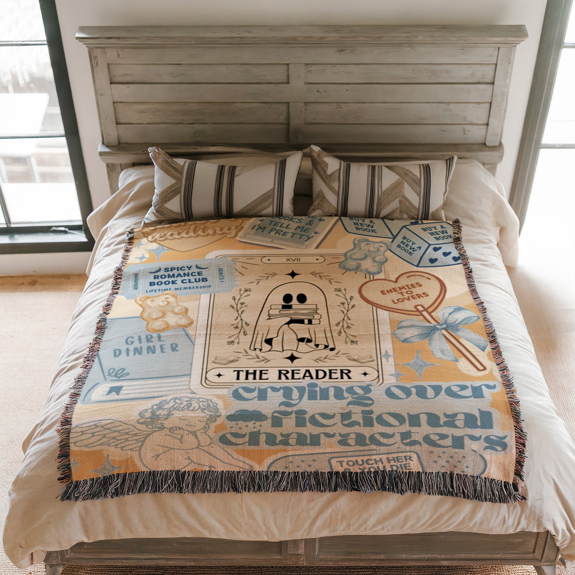 a bed with a blanket that has various text and illustrations on it, including a ghost, a book, and other decorative elements.