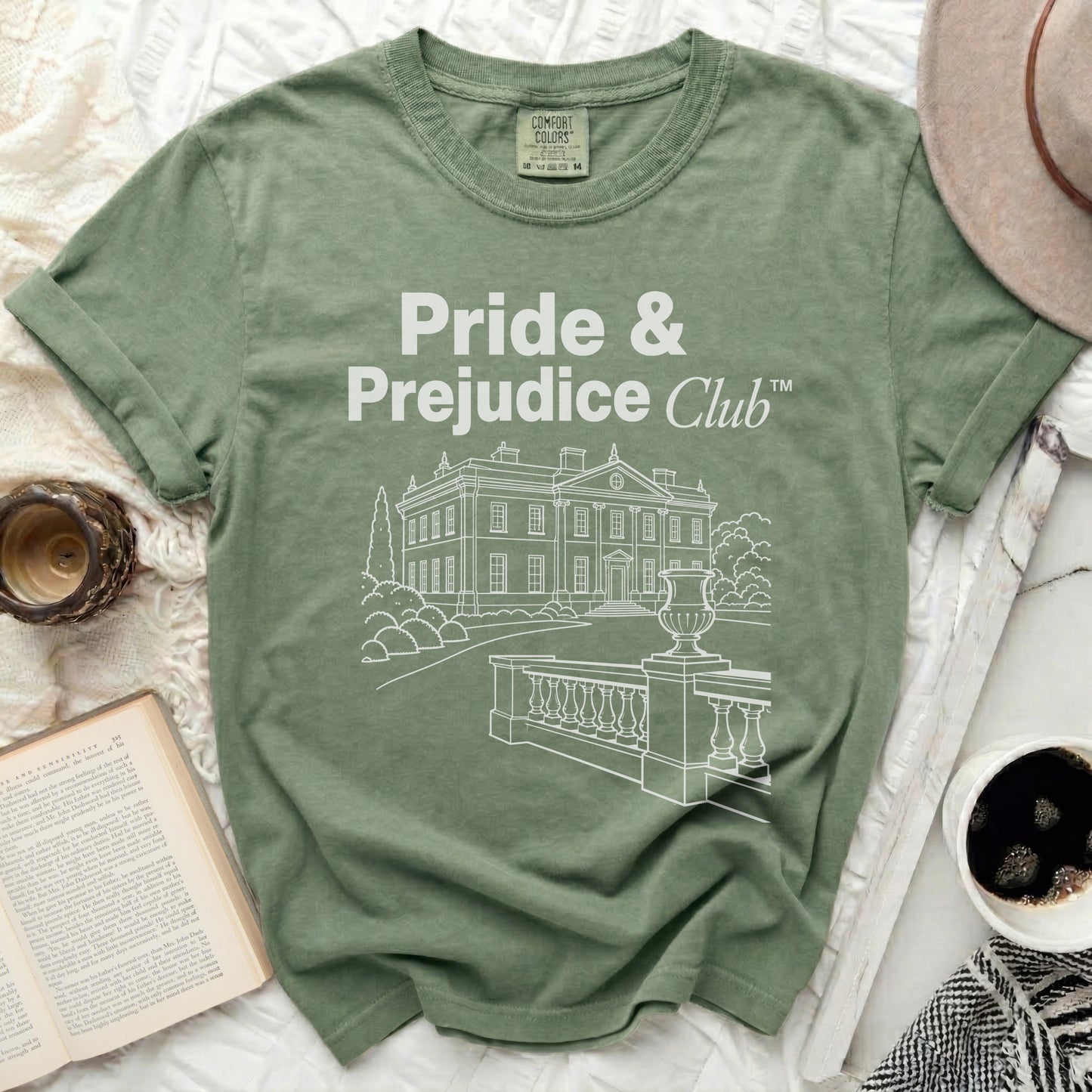 Green t-shirt with "Pride & Prejudice Club" and a house design.