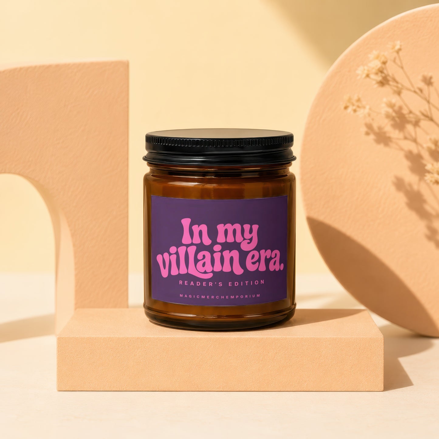 Brown glass candle with purple label reading "In my villain era. Reader's Edition. MagicMerchEmporium."