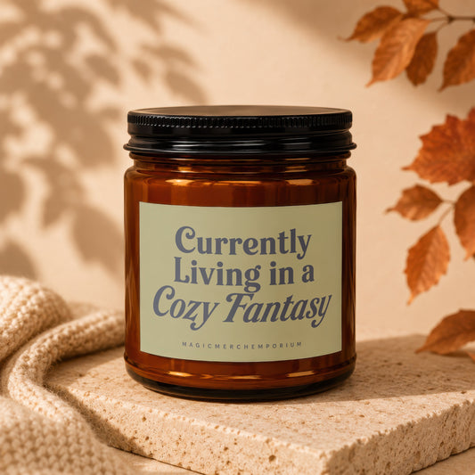 Amber jar candle with label reading "Currently Living in a Cozy Fantasy".