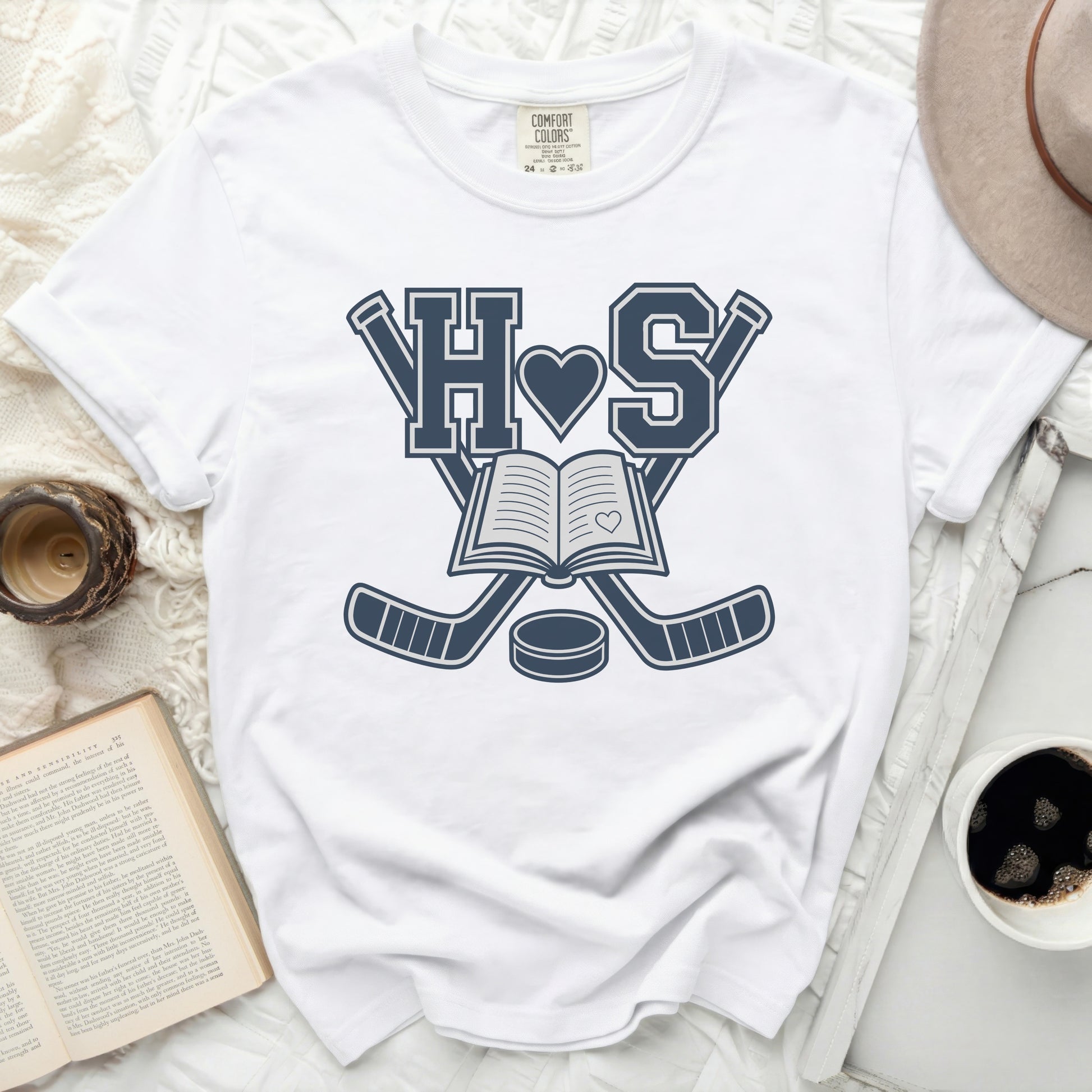 White t-shirt with navy blue "HS" over an open book and hockey sticks.