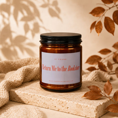 Amber candle with black lid, "Return Me to the Bookstore" text, and autumn leaf decor.