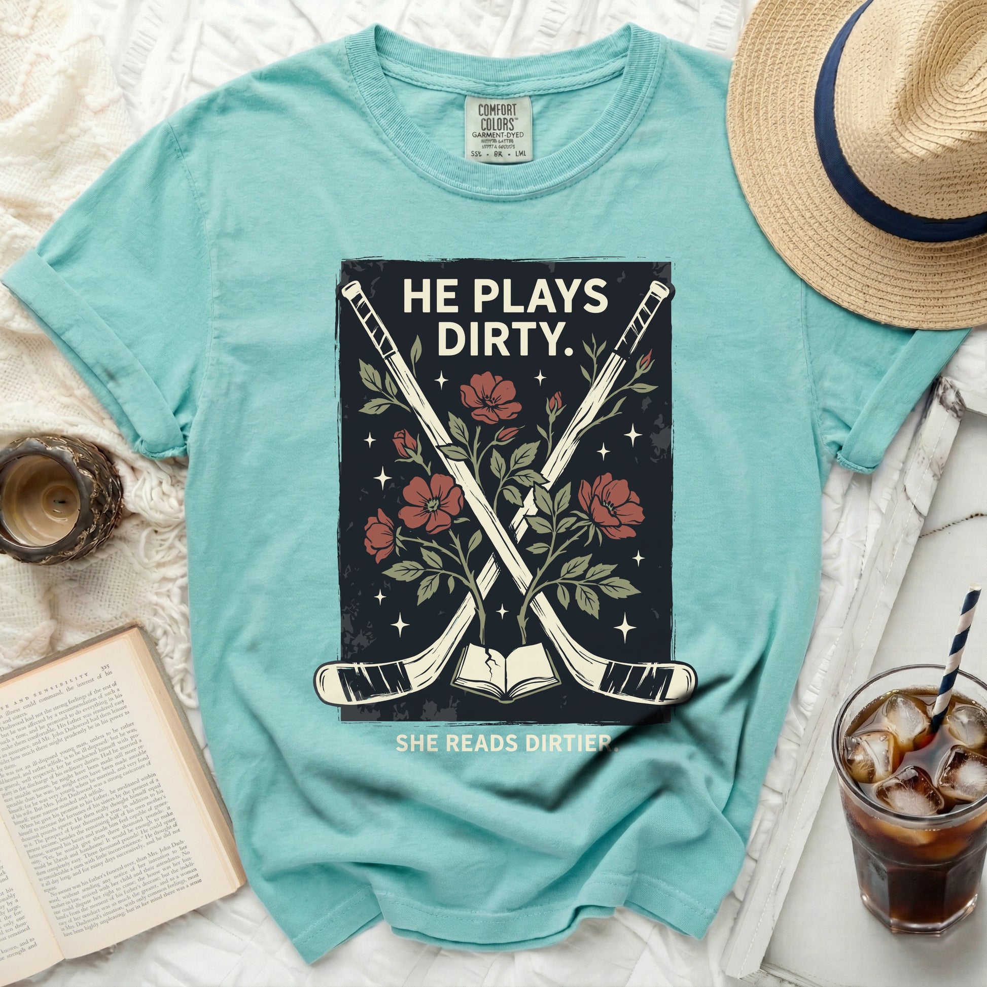 "He Plays Dirty. She Reads Dirtier." text on teal t-shirt with crossed hockey sticks and flowers.
