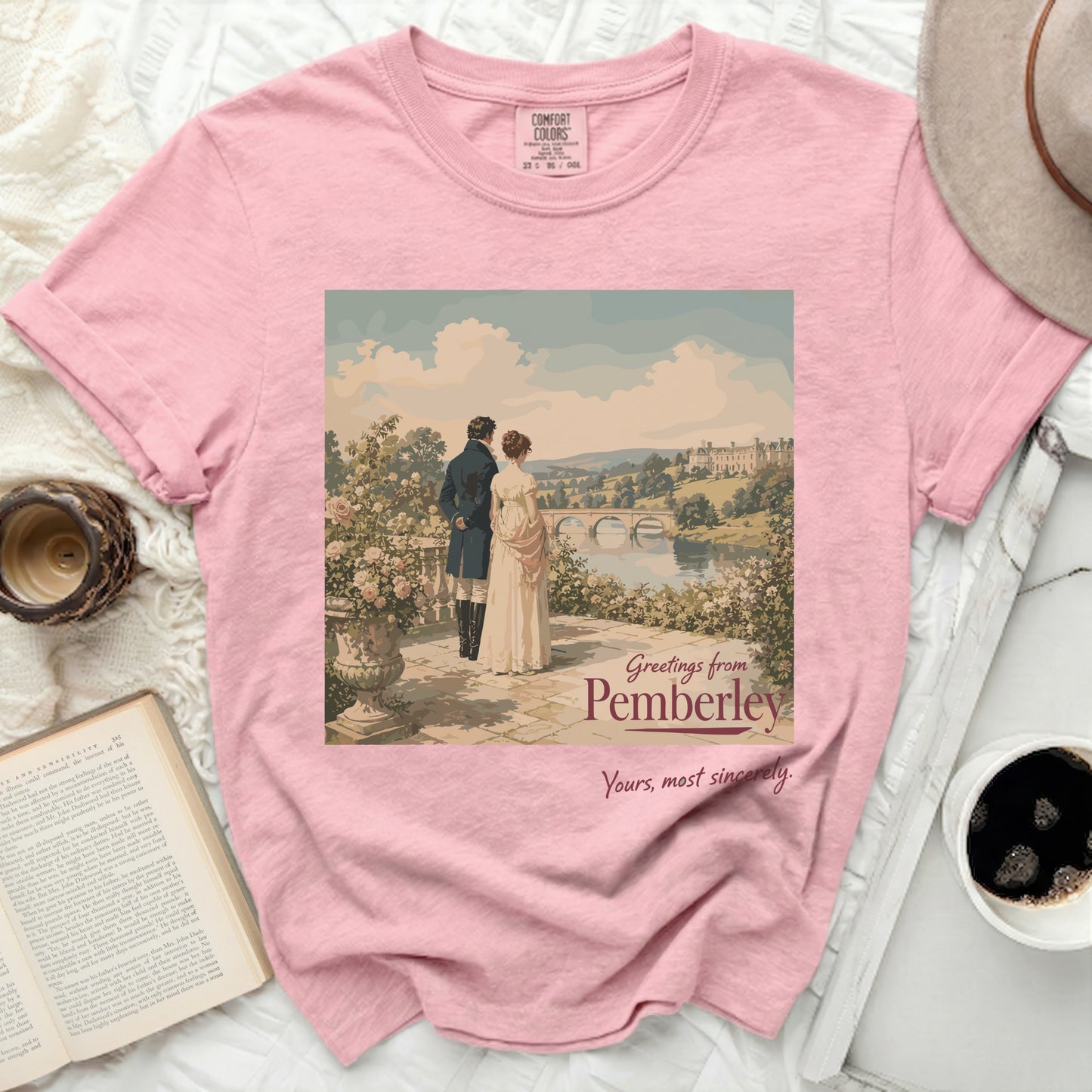 Pink t-shirt with "Greetings from Pemberley" artwork and a couple with a castle.