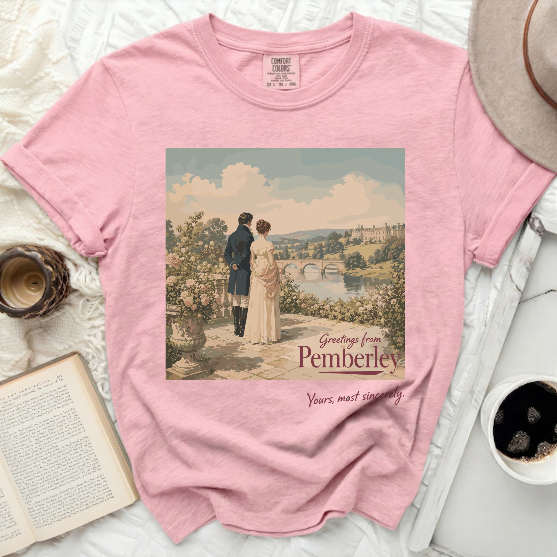 Pink t-shirt with "Greetings from Pemberley" artwork and a couple with a castle.