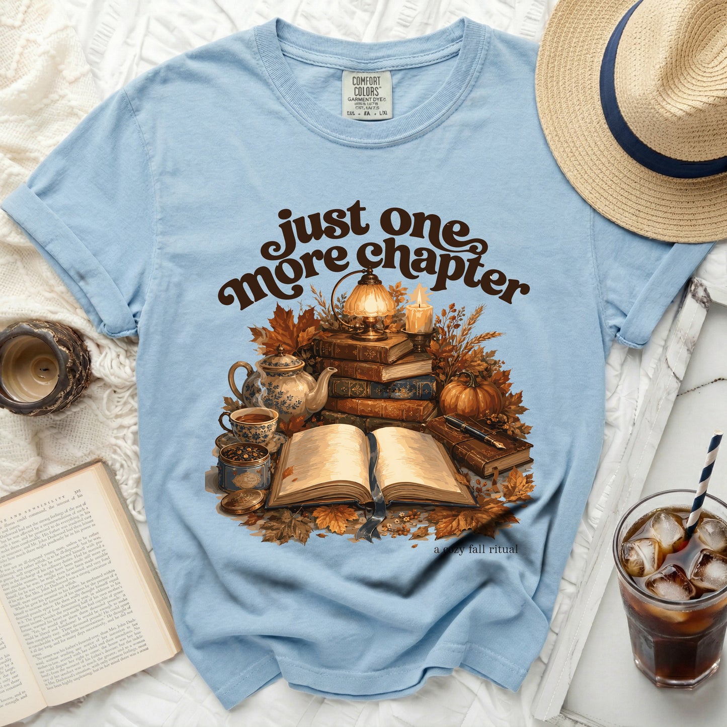 Light blue t-shirt with "just one more chapter" and autumn reading graphic.