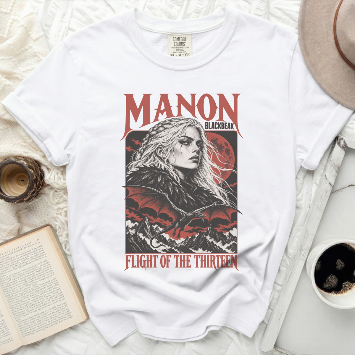 White t-shirt with "MANON BLACKBEAK" and "FLIGHT OF THE THIRTEEN" text graphic.