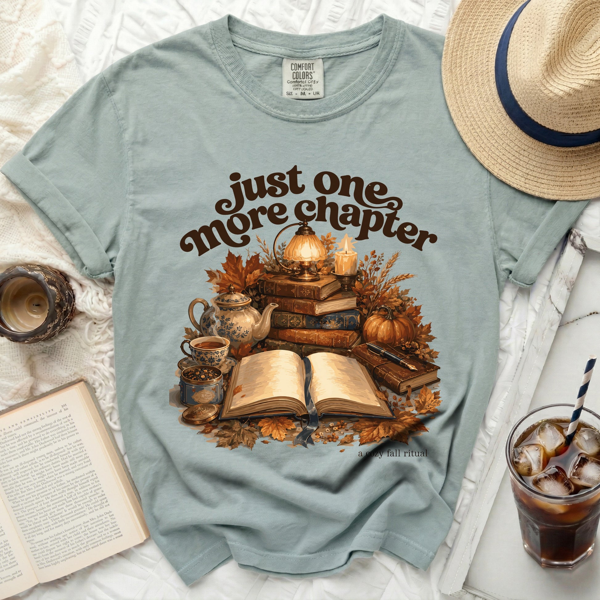 Green t-shirt with "just one more chapter" and a cozy fall book scene.