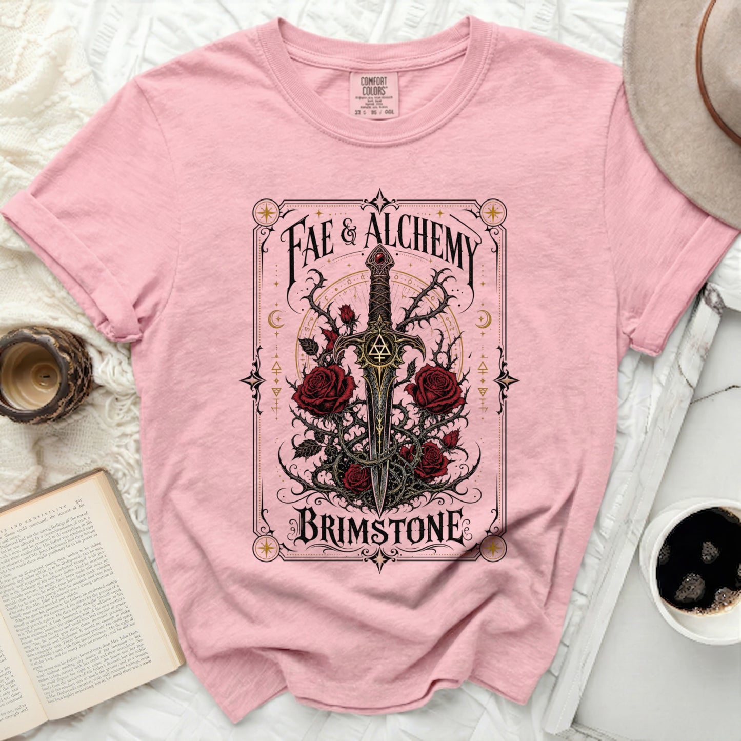 Pink t-shirt with "Fae & Alchemy Brimstone" text and sword with roses.