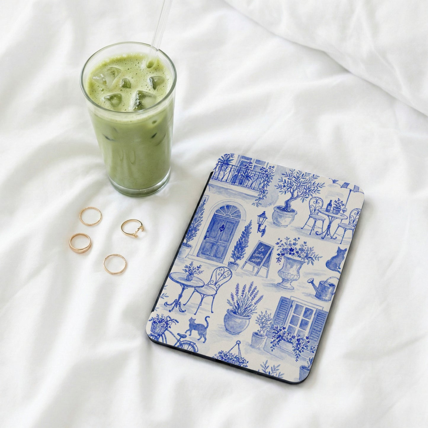 Tablet case with blue and white French garden scene and a glass of iced matcha.