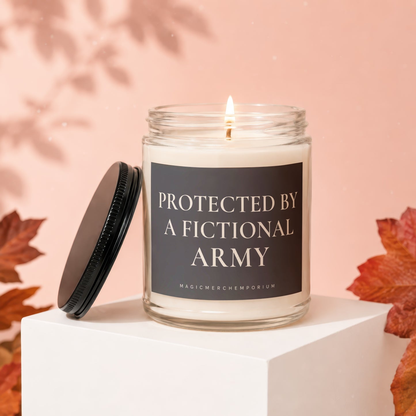 Glass candle with a burning wick and text "Protected by a Fictional Army".
