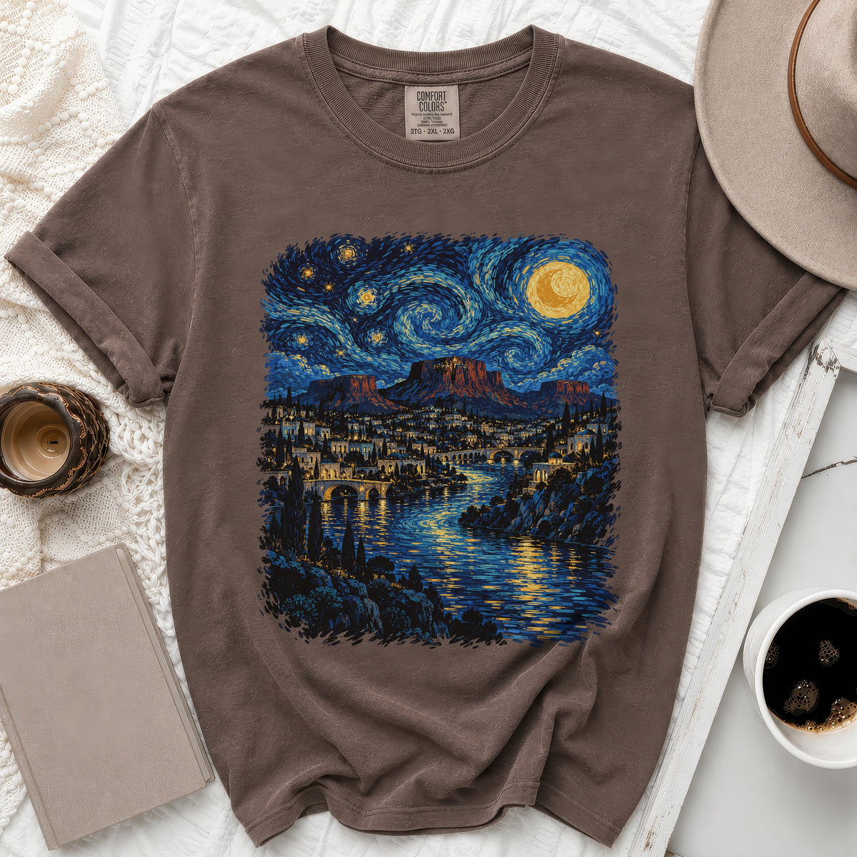 Brown t-shirt featuring a Van Gogh-style night sky over a cityscape with a river.