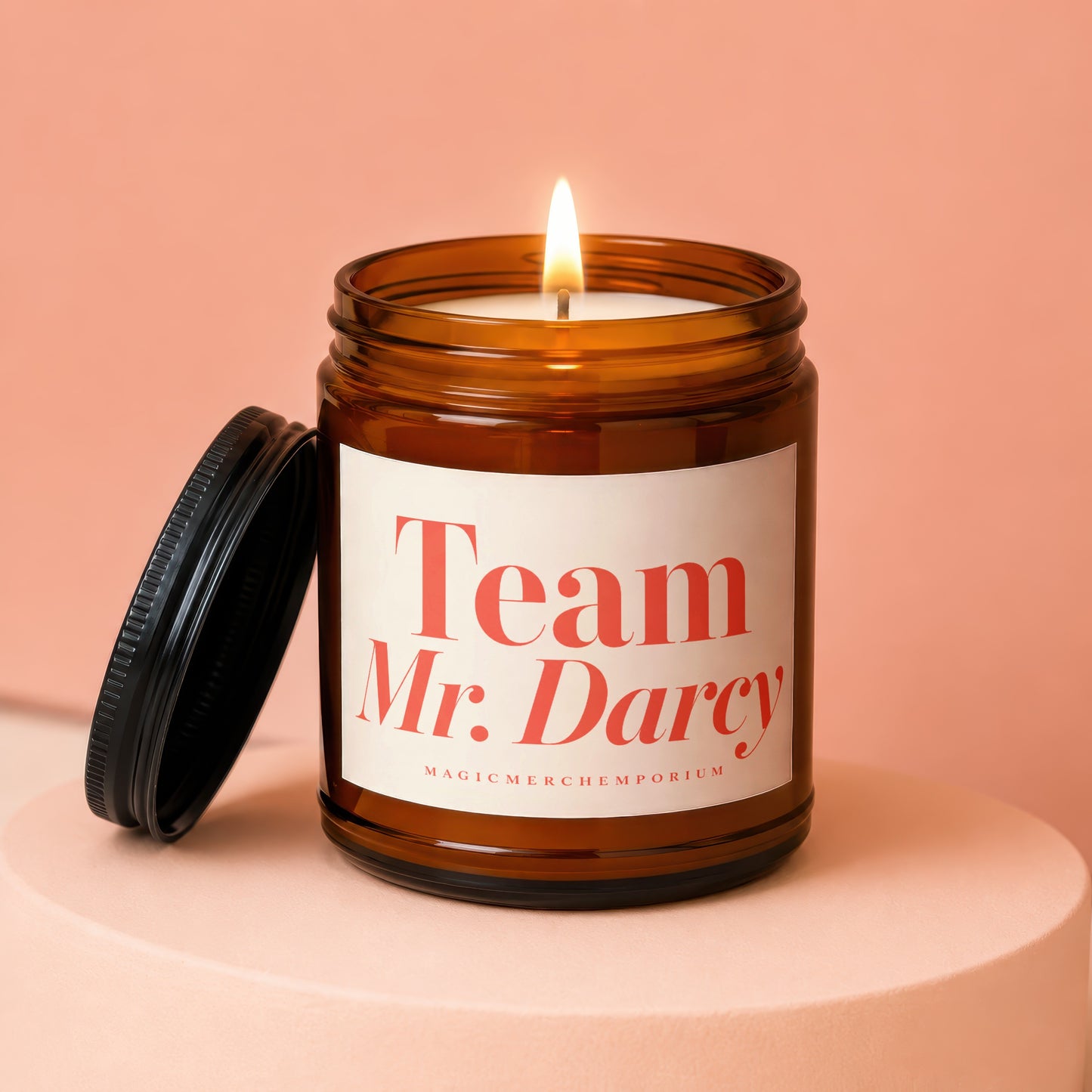Amber jar candle with a lit wick labeled "Team Mr. Darcy" and "MagicMerchEmporium".