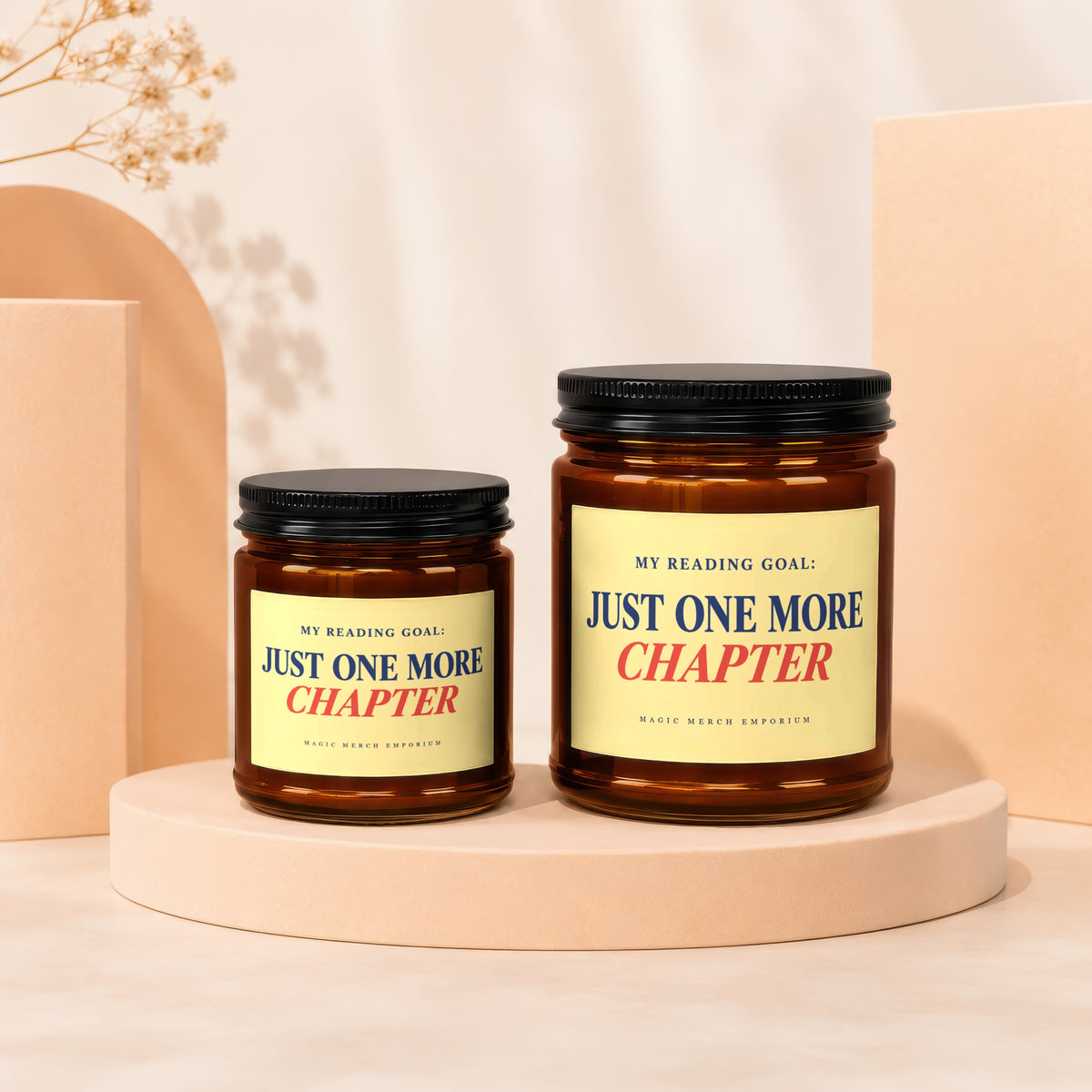 Two amber glass candles with black lids labeled "Just One More Chapter."