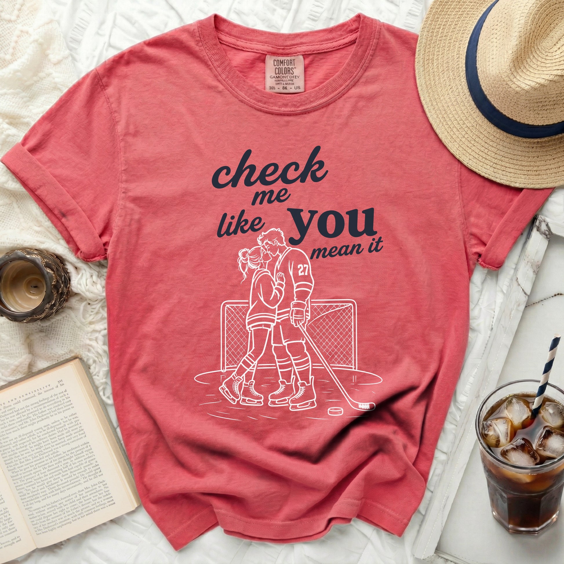 Red t-shirt with "check me like you mean it" graphic and hockey couple illustration.
