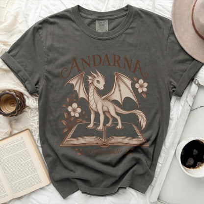 Dark grey t-shirt with a drawing of a dragon on an open book and text "ANDARNA A little wonder".