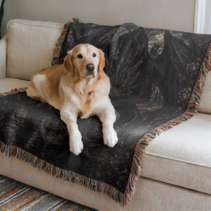 A golden retriever dog is lying on a black and brown patterned blanket on a beige couch.