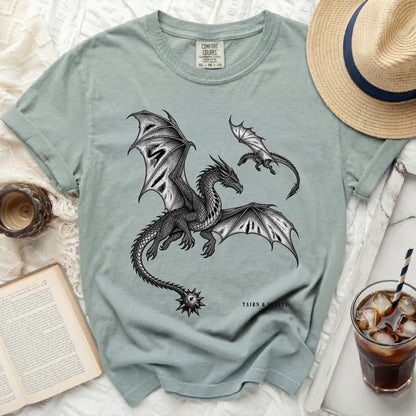 Light blue t-shirt with black dragon print and "TAIRN & SGAEYL" text.