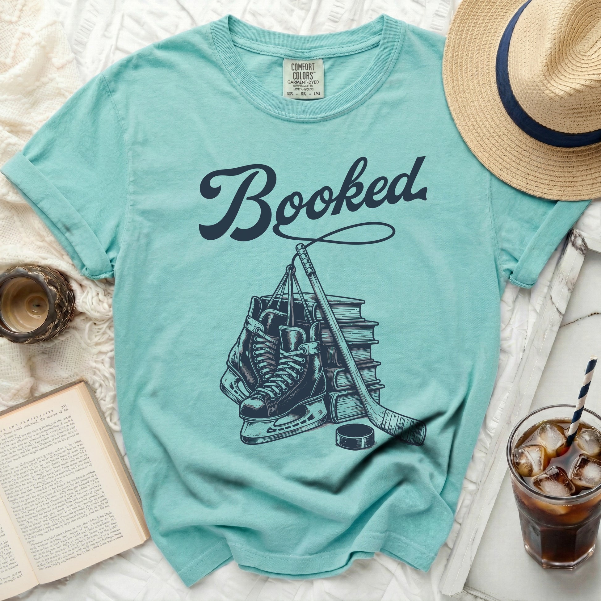 Aqua t-shirt with "Booked" text and hockey skates, stick, and puck illustration.