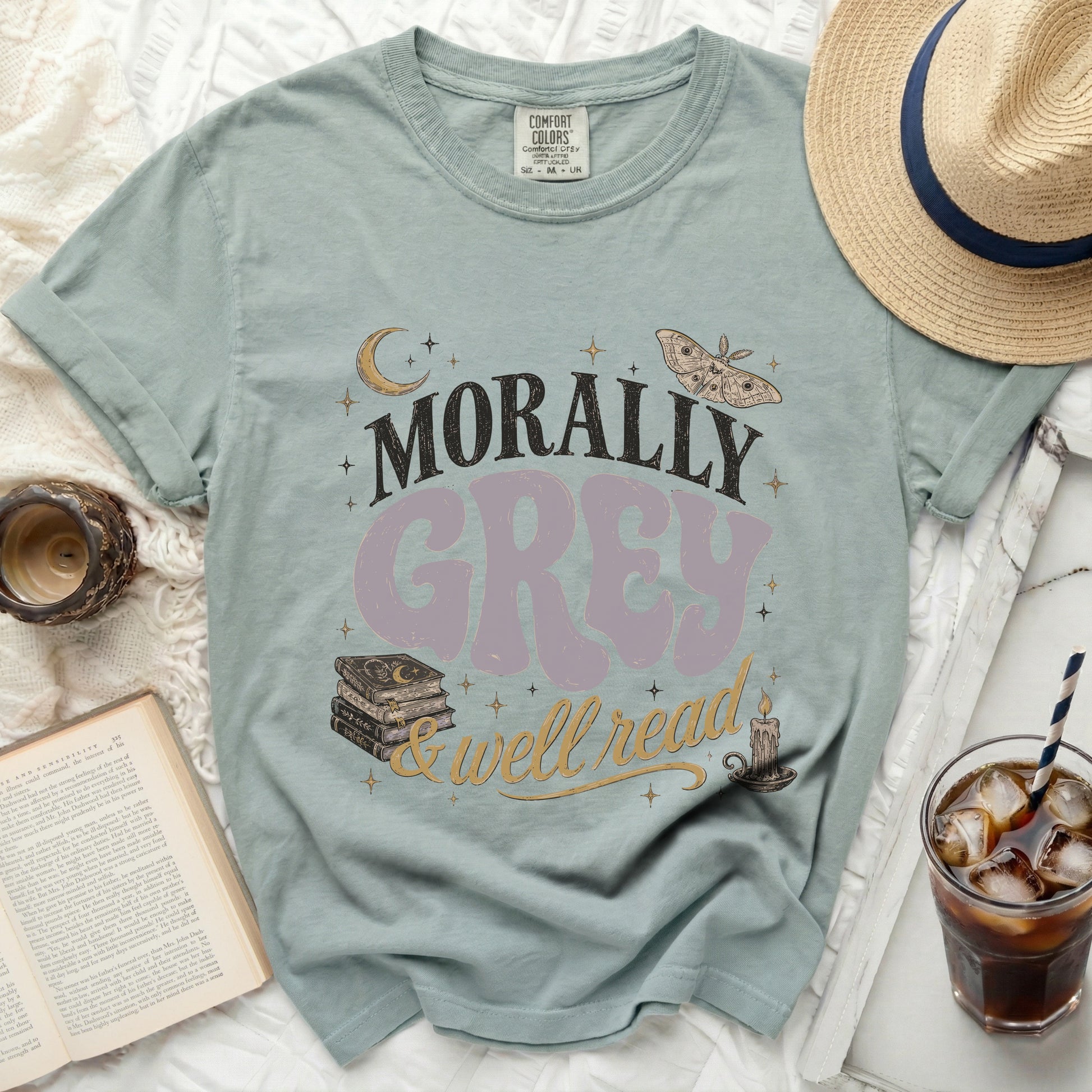 Morally Grey & Well Read text on a pale blue t-shirt with book and moth graphics.