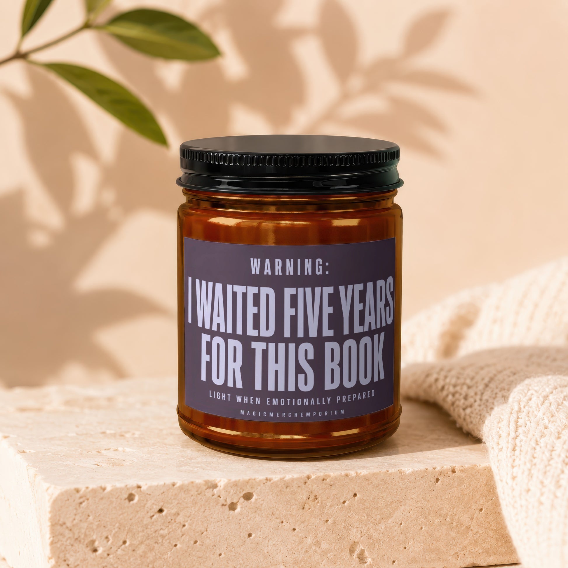 Amber candle with black lid and "I waited five years for this book" label.