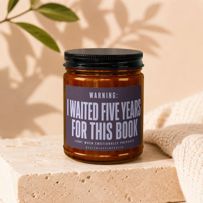 Amber candle with black lid and "I waited five years for this book" label.
