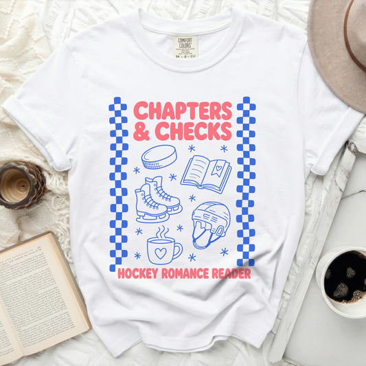 White t-shirt with blue graphic of hockey skates, puck, and book for "Chapters & Checks"