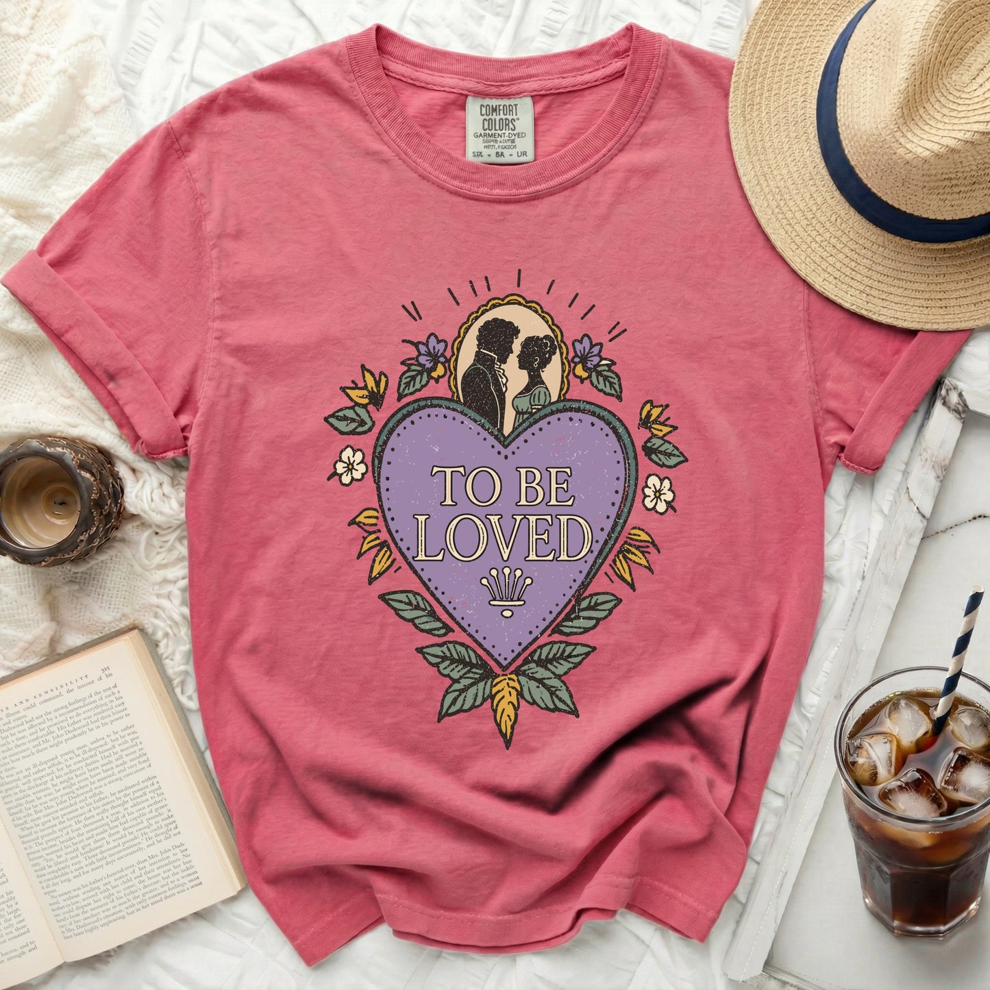 Pink Comfort Colors t-shirt with "To Be Loved" graphic and romantic couple silhouette.
