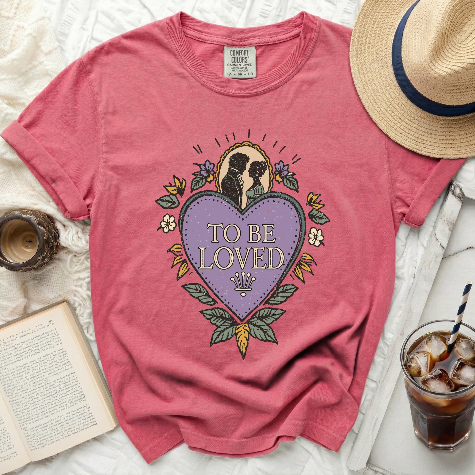Pink Comfort Colors t-shirt with "To Be Loved" graphic and romantic couple silhouette.
