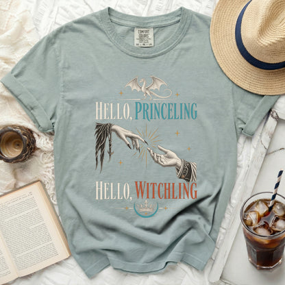 Green t-shirt with dragon and hands graphic, saying "Hello, Princeling Hello, Witchling".