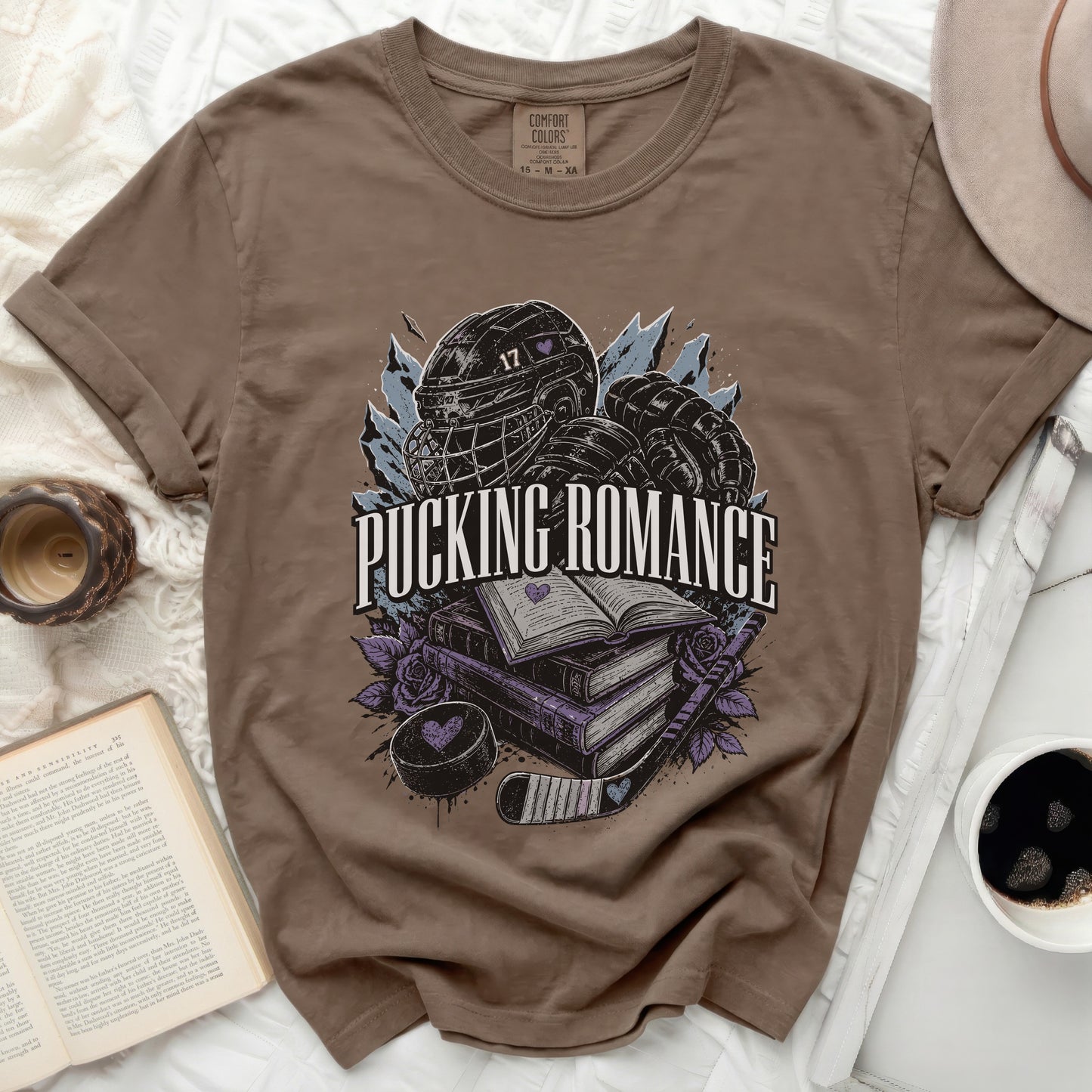 Brown t-shirt with "Pucking Romance" text, hockey gear, and books.