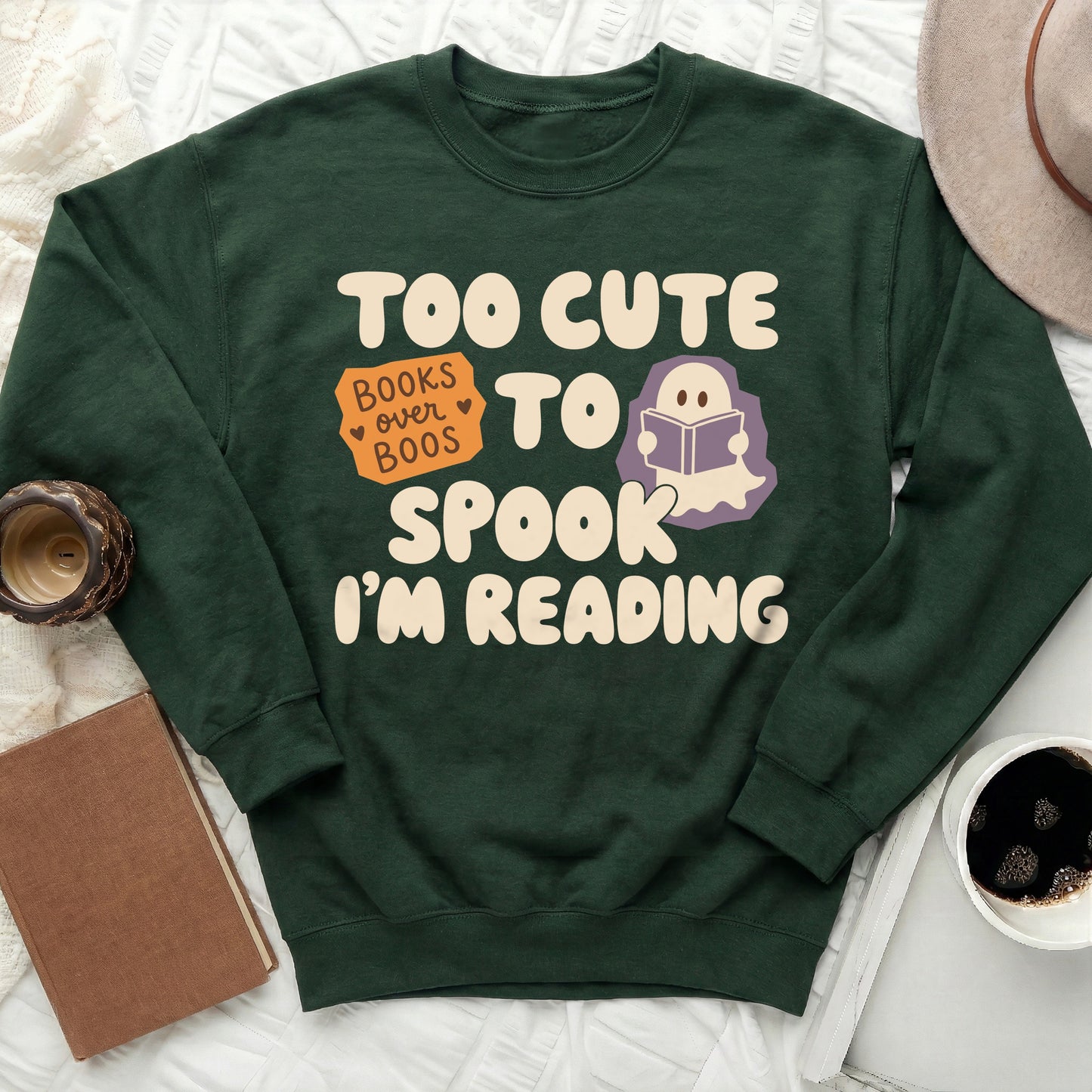 Dark green sweatshirt with "Too Cute To Spook, I'm Reading" text and ghost icon.