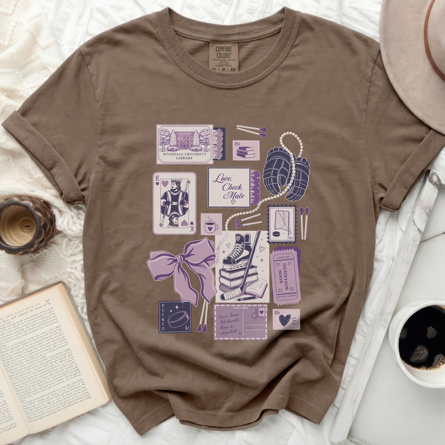 T-shirt with pastel graphic of playing cards, books, and hockey items.