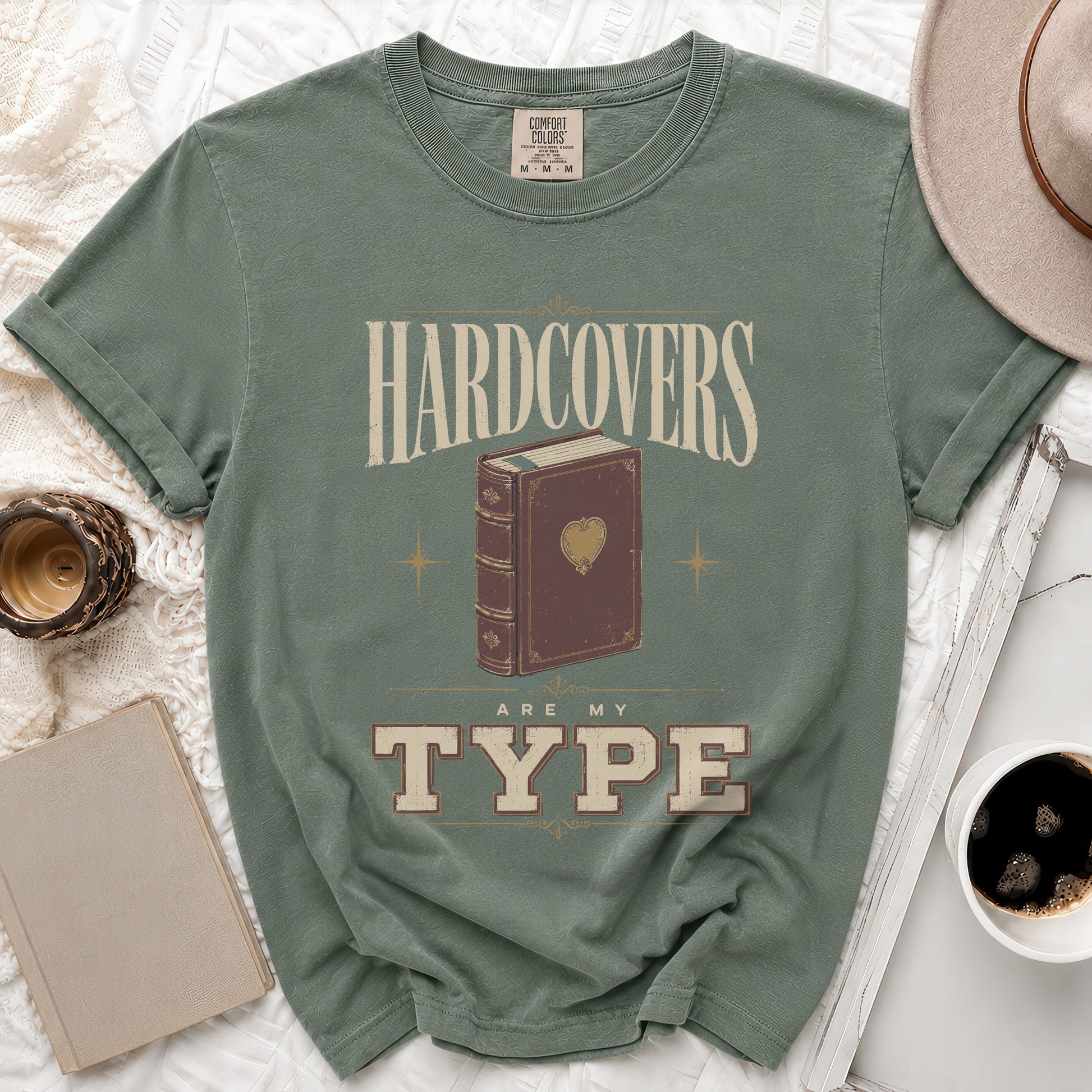 Green t-shirt with "Hardcovers are my type" and a book design.