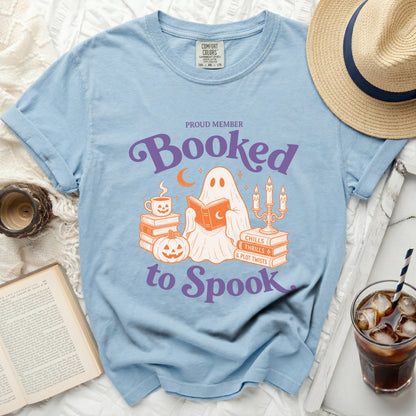 Light blue t-shirt with ghost reading books, "Proud Member Booked to Spook" graphic.