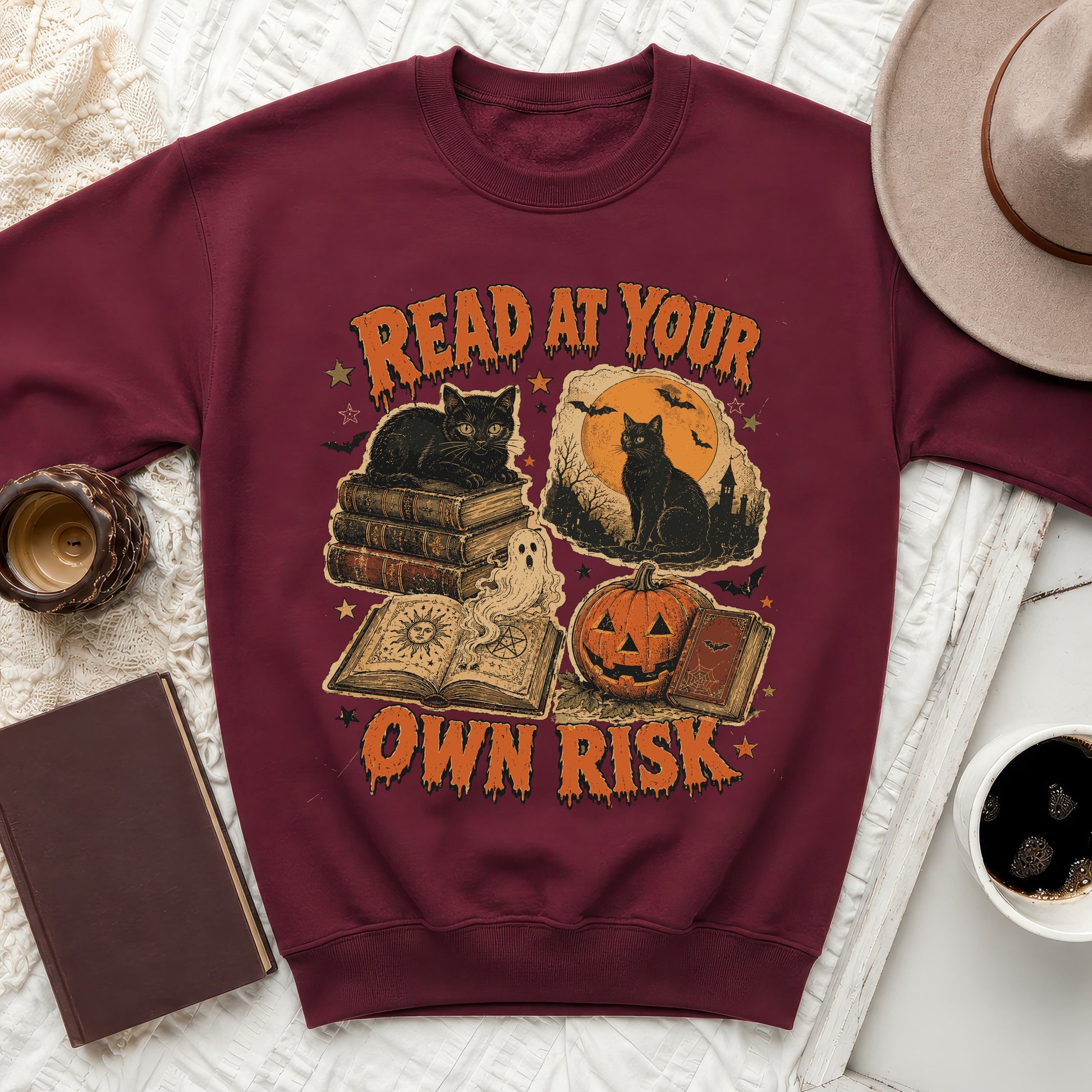 Maroon sweatshirt with "READ AT YOUR OWN RISK" Halloween graphic featuring cats and books.