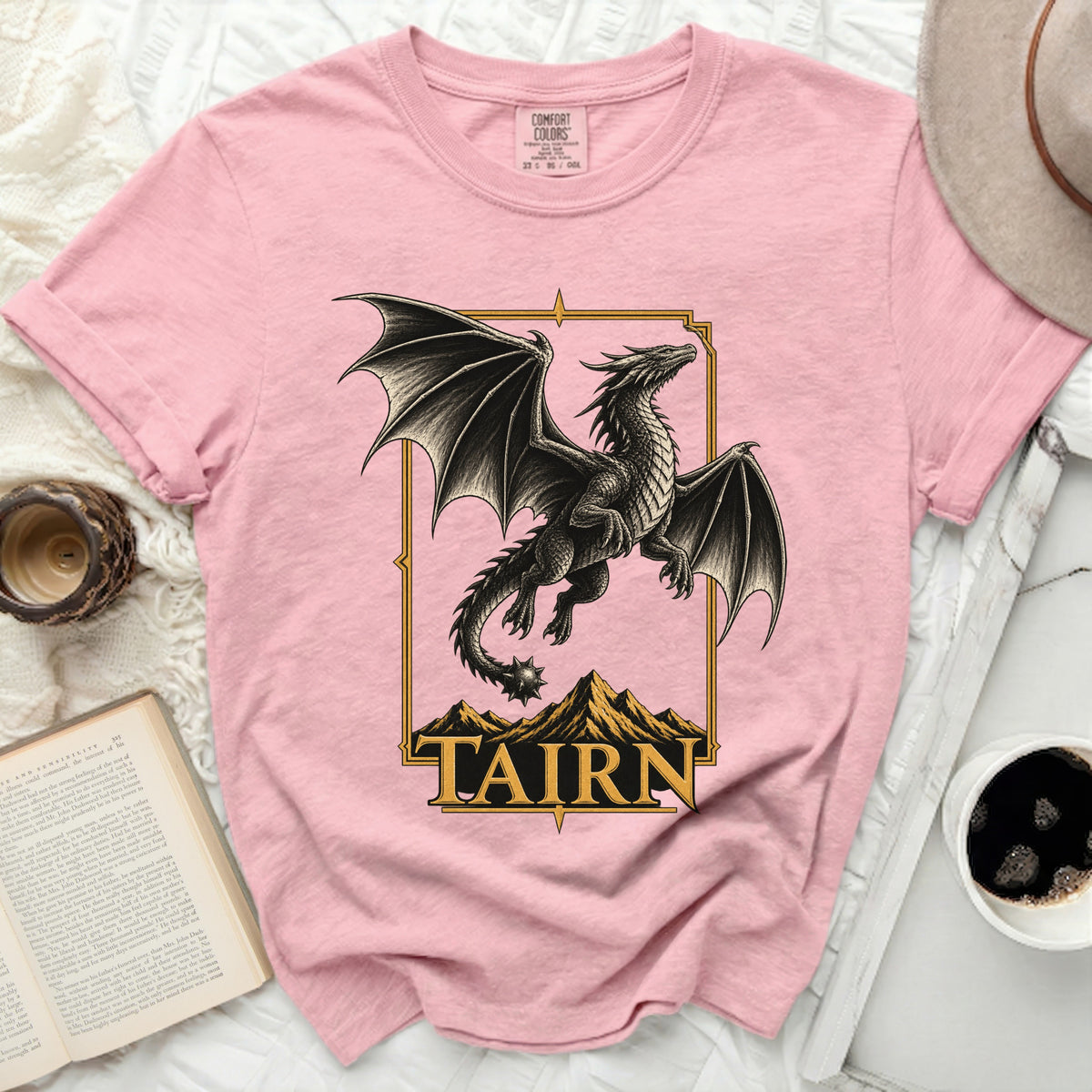 Pink t-shirt with a black dragon design and the word "TAIRN" in gold lettering.